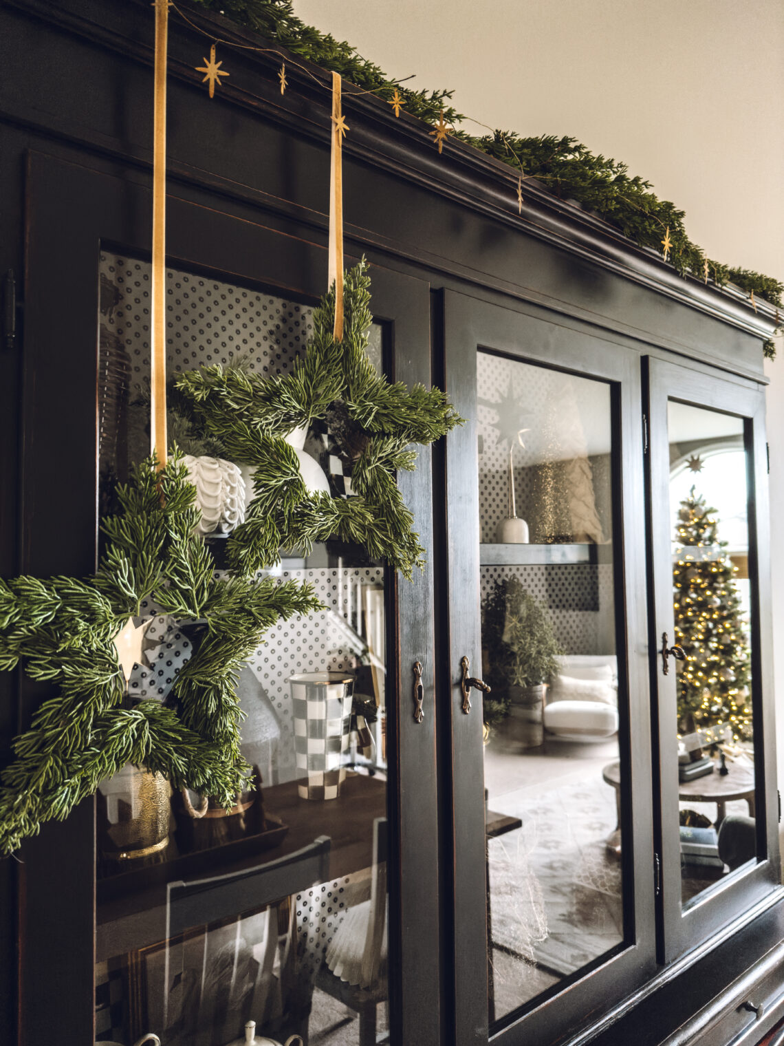 Christmas star wreaths hanging from ribbon on the cabinet