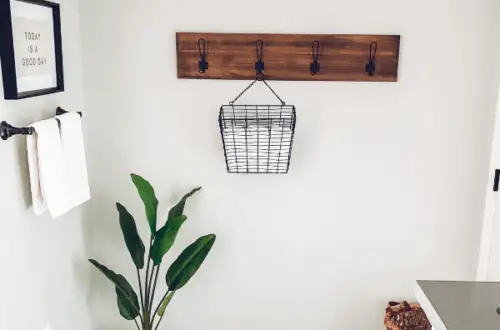 This shows a basket holding towels, hanging on a hook in the bathroom.