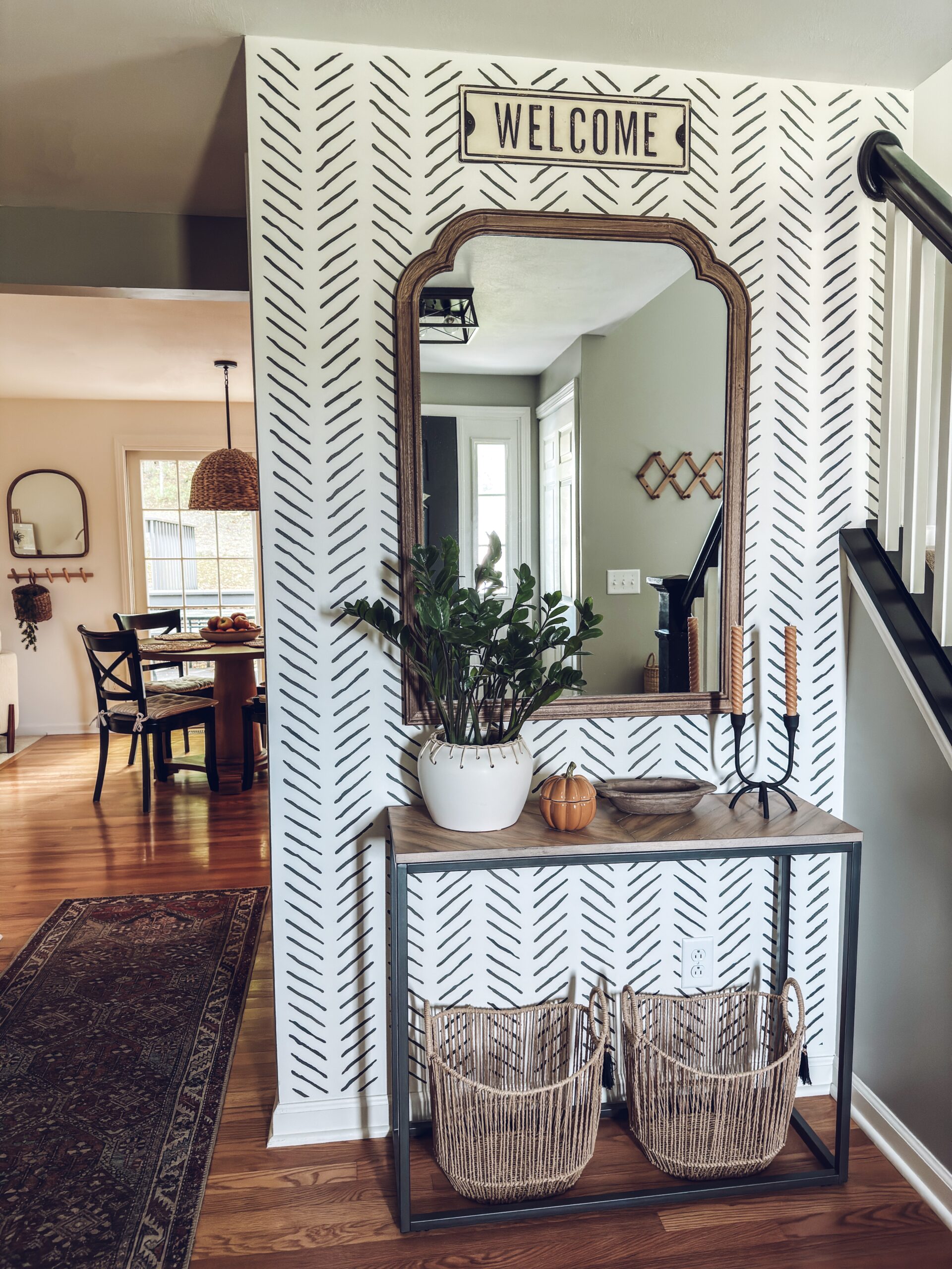 black candle holder and a lidded pumpkin candle on the console table