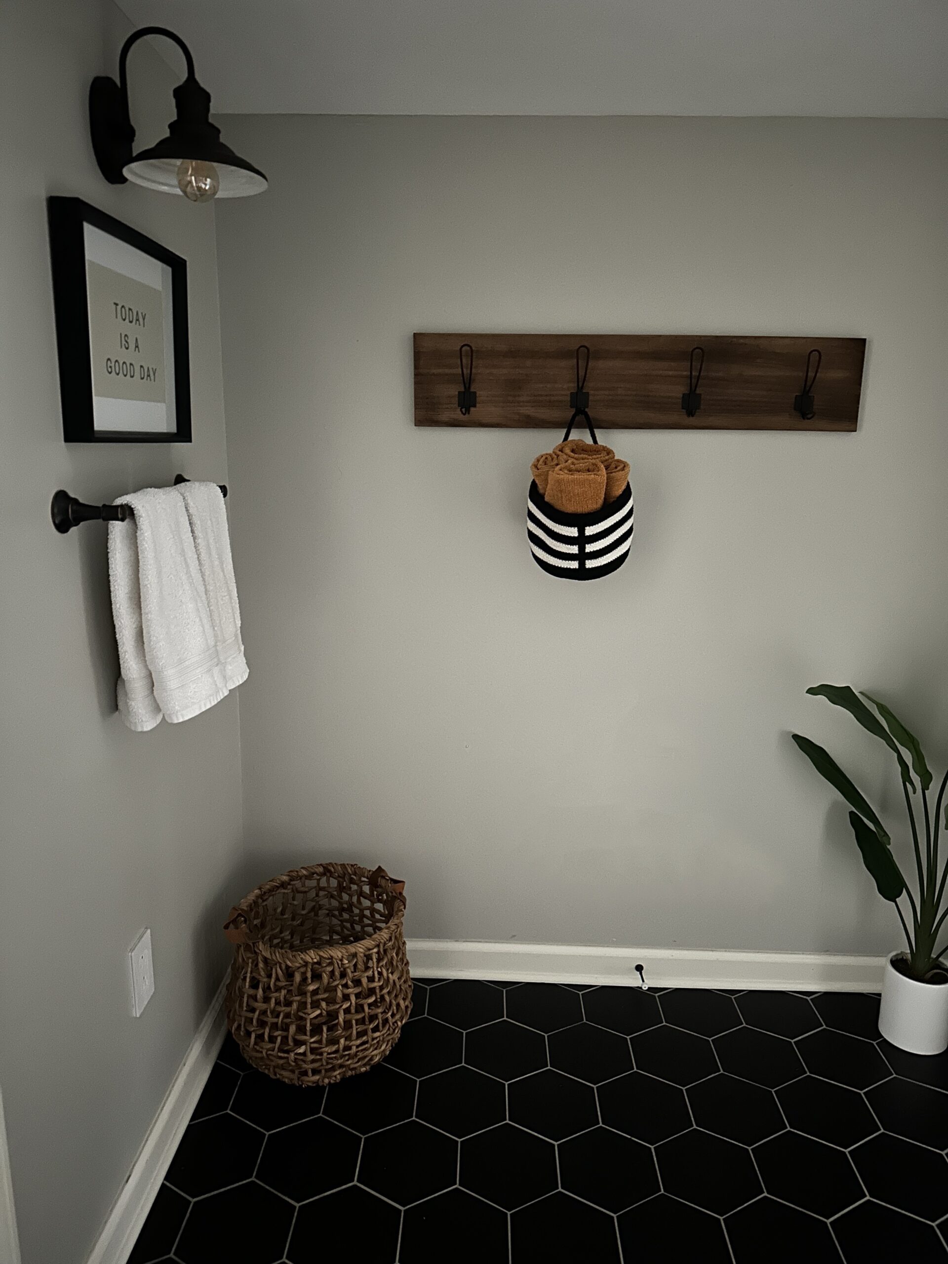 mustard yellow towels rolled up in a hanging basket on a hook in the bathroom for fall