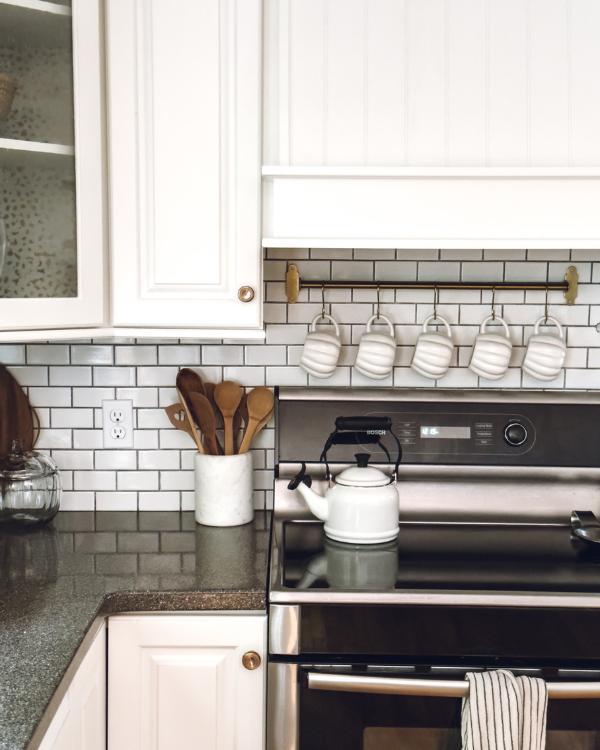 A row of white pumpkin mugs hanging above the stove