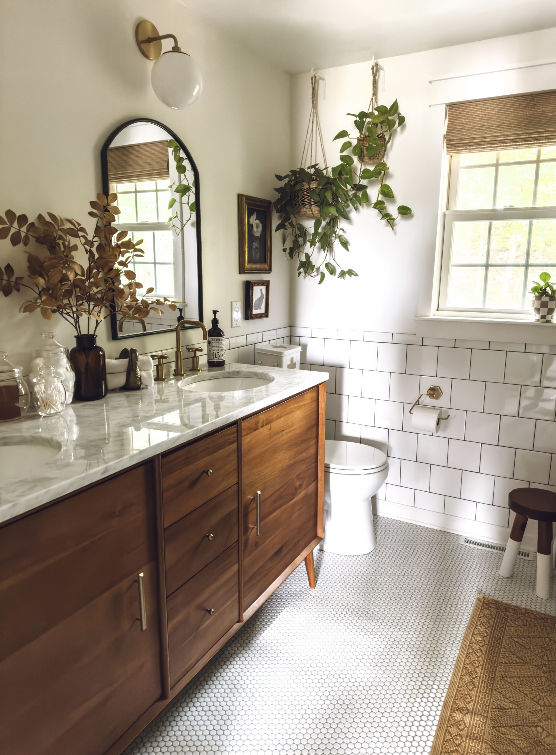 amber glass vase with fall branches on the bathroom counter