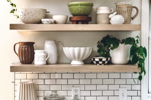 The green Mason Cash bowl on kitchen shelving containing neutral decor adds color to the kitchen