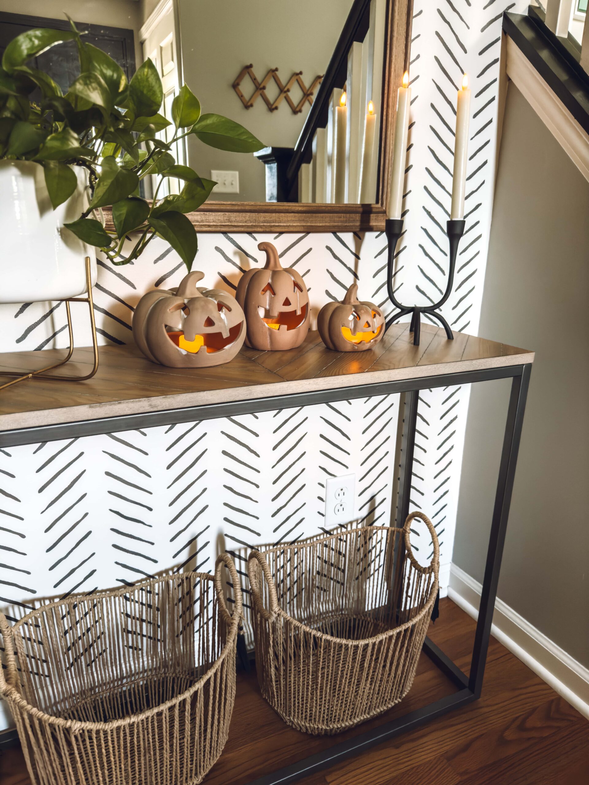3 lit up terracotta jack o lanterns on the entry table